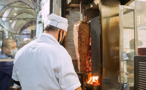 a man standing near the gyros grill