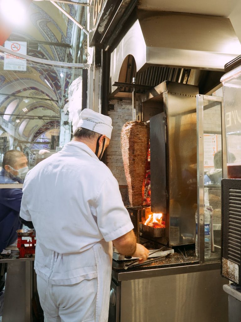 a man standing near the gyros grill
