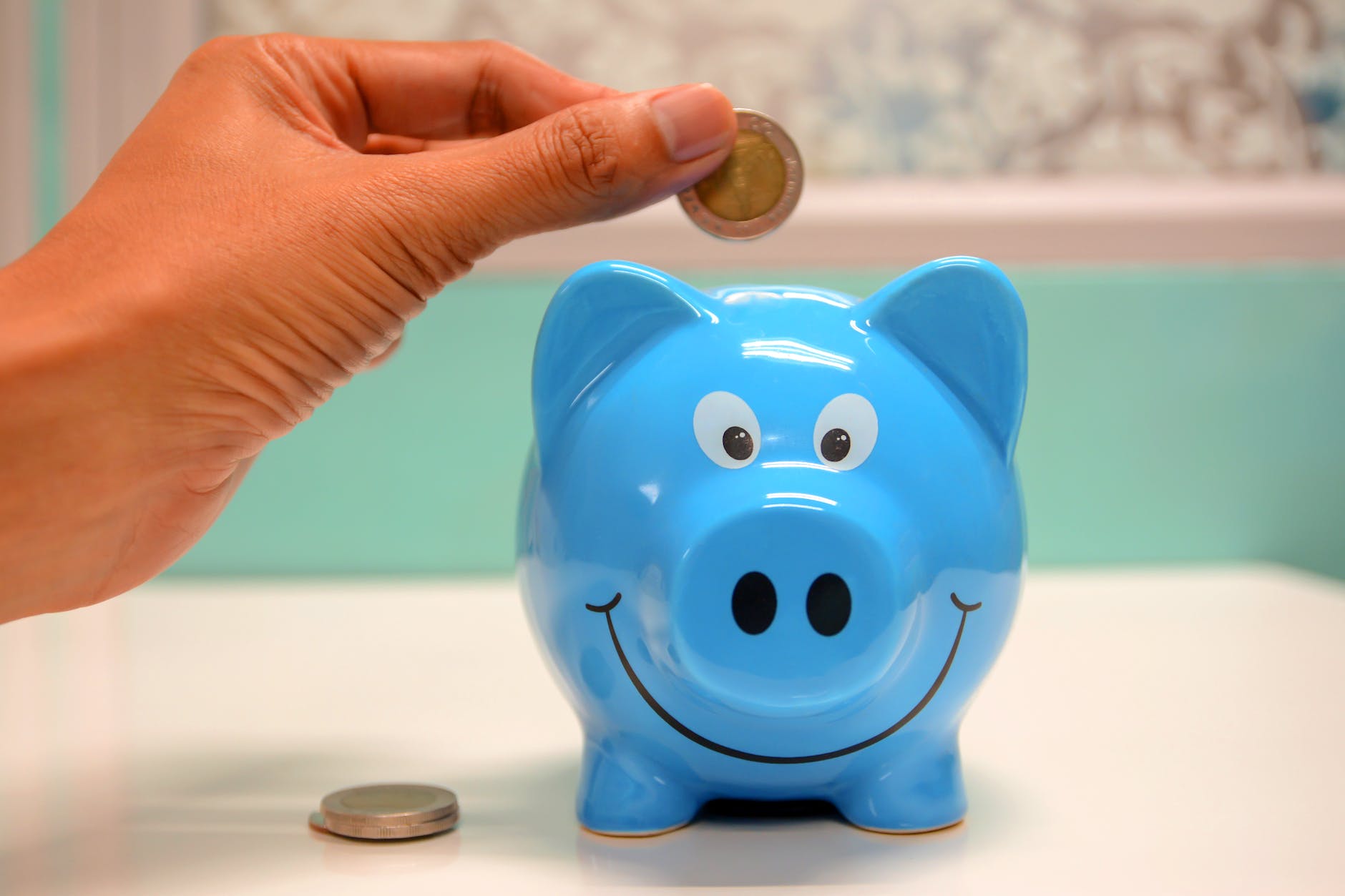 Learn to save and make money with Bravely Go (image of person putting coin in a piggy bank)