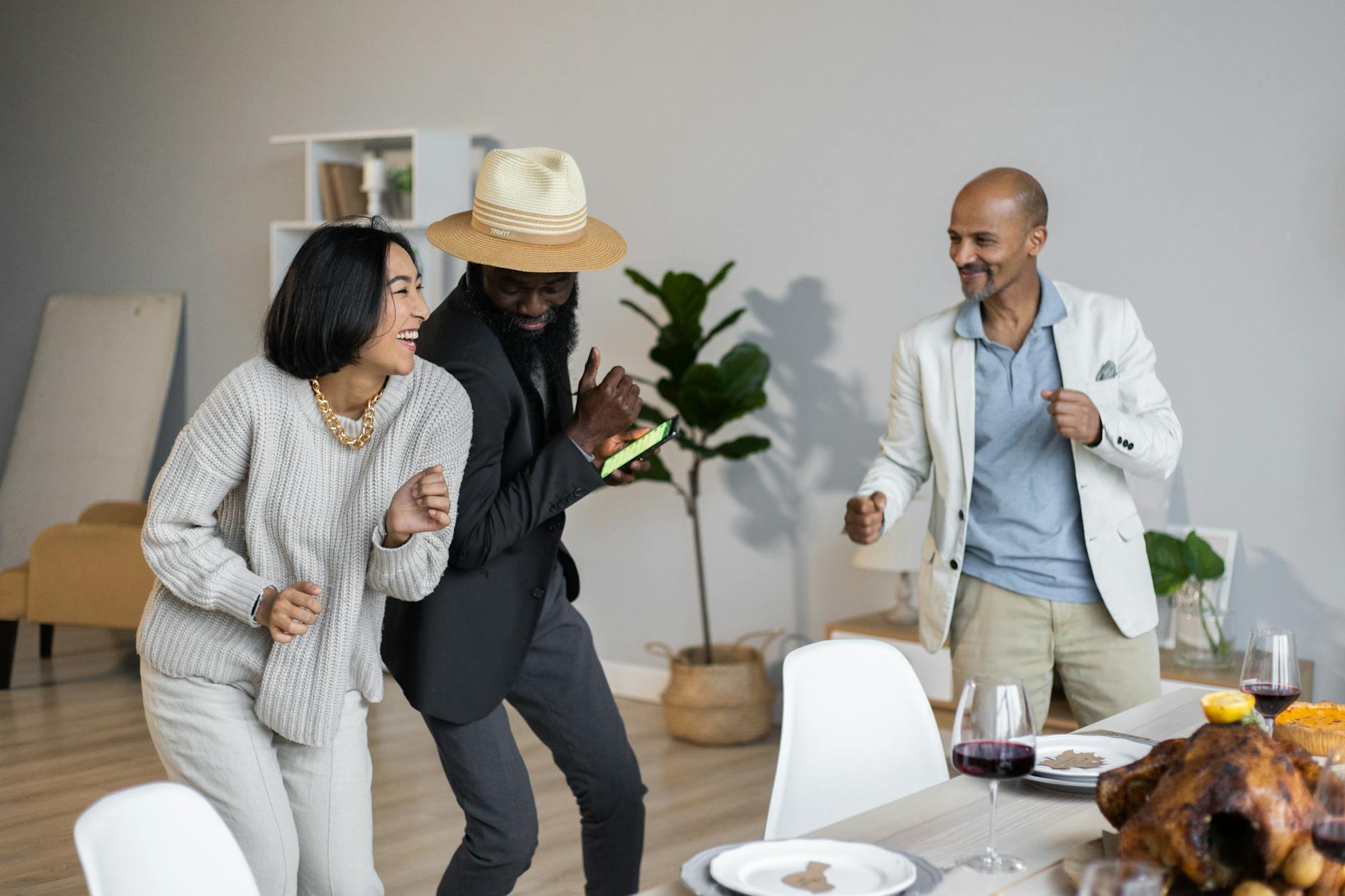 positive diverse friends dancing while celebrating Thanksgiving
